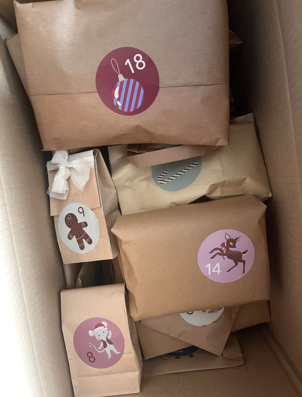 Un calendrier de l’Avent My.boxforyou avec des cadeaux emballés en papier kraft et des étiquettes de Noël numérotées